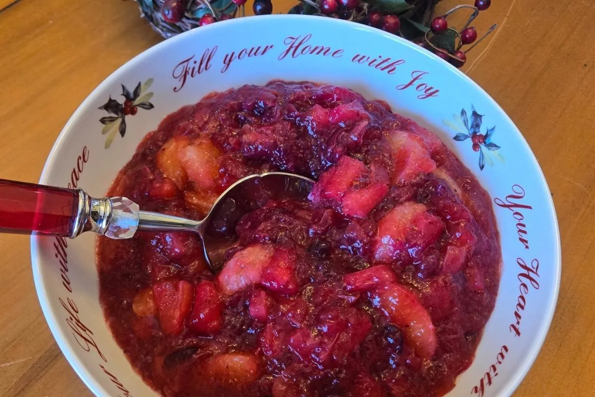 Jell-O with chunks of fruit, in a decorative bowl with holiday-themed text.