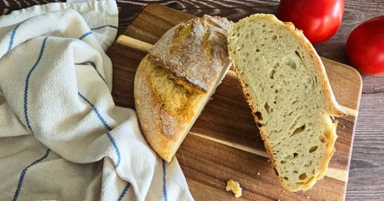 Rustic sourdough artisan bread with a crisp crust and soft interior, baked at home and photographed in natural light on a wooden board.