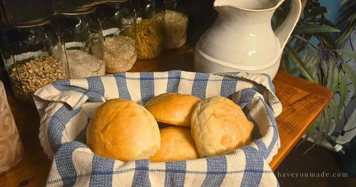 Soft homemade dinner rolls made from sandwich bread dough, brushed with butter and served warm in a lined basket